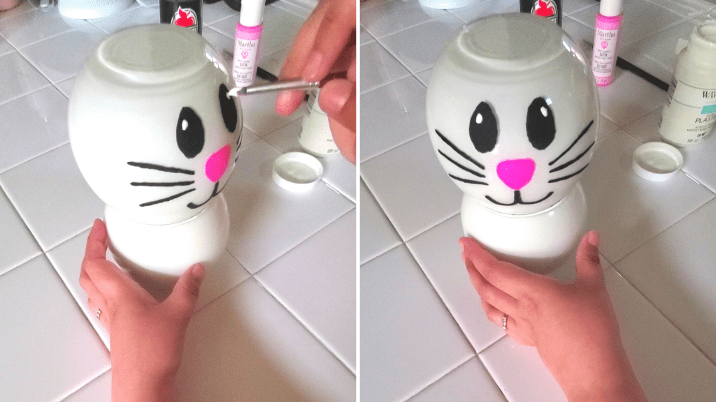 painting a line with the black paint underneath the nose and create two curved lips stemming from that line
Add a single white dot to the bunny's eyes to make them look more animated. 