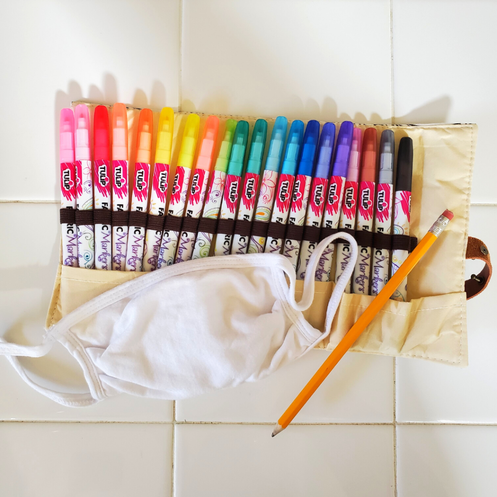 This quick and easy DIY Bunny Face Mask is perfect for kids and adults alike! This Easter face mask DIY makes for some spring fun for families, too! This mask pairs well with a spring or Easter outfit and is a great Easter basket for kids!
For this project, you'll need a cotton face mask, fabric markers, and a pencil. 